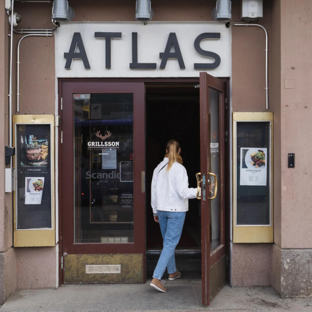 Nainen astumassa sisälle Scandic Atlakseen